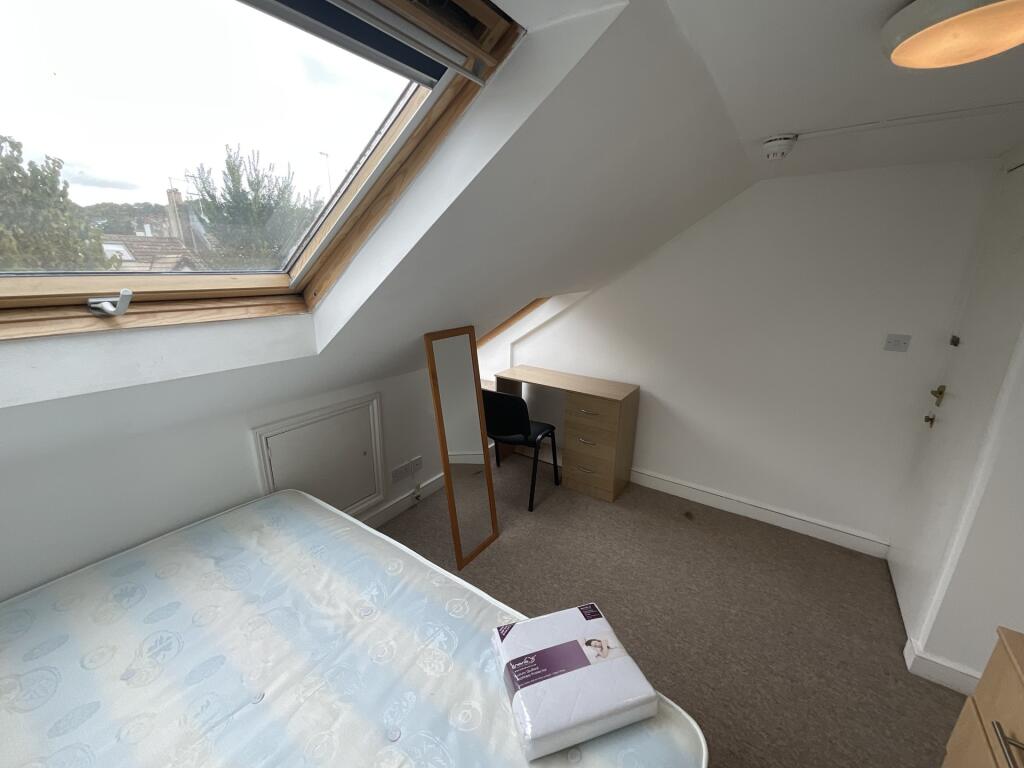 Bright and tidy attic bedroom with a large skyl...