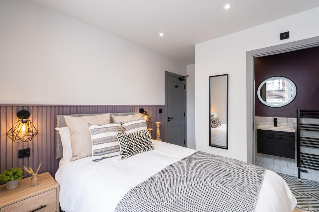 Modern and stylish master bedroom with a cozy b...