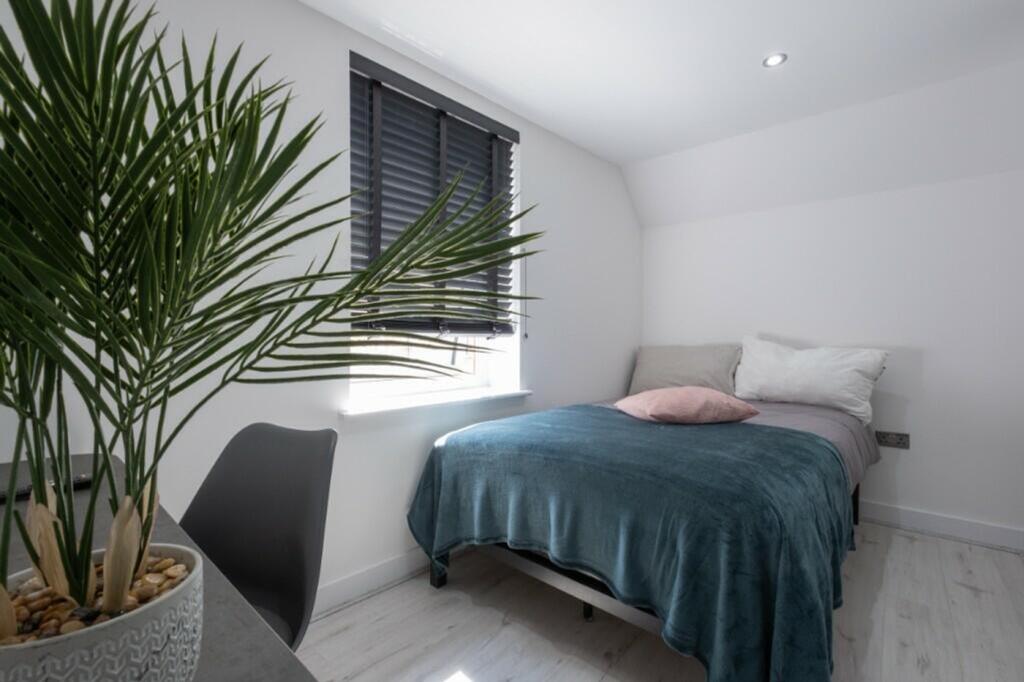 This inviting double bedroom features a cozy am...