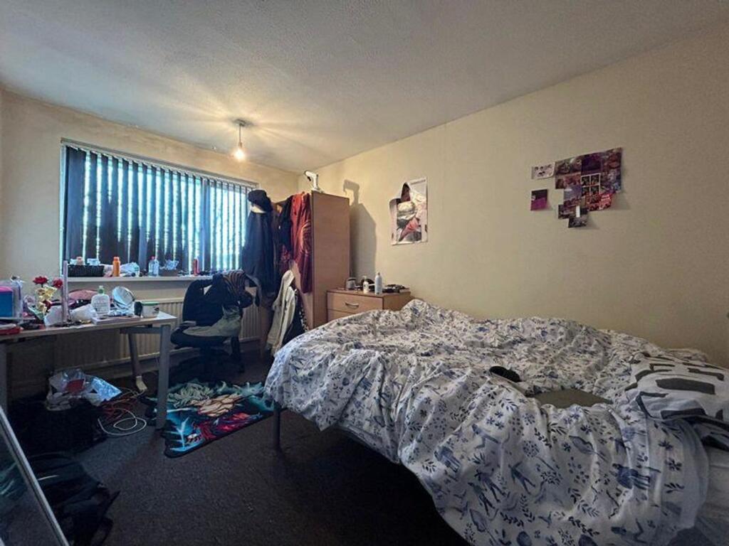 A spacious double bedroom with ample natural li...