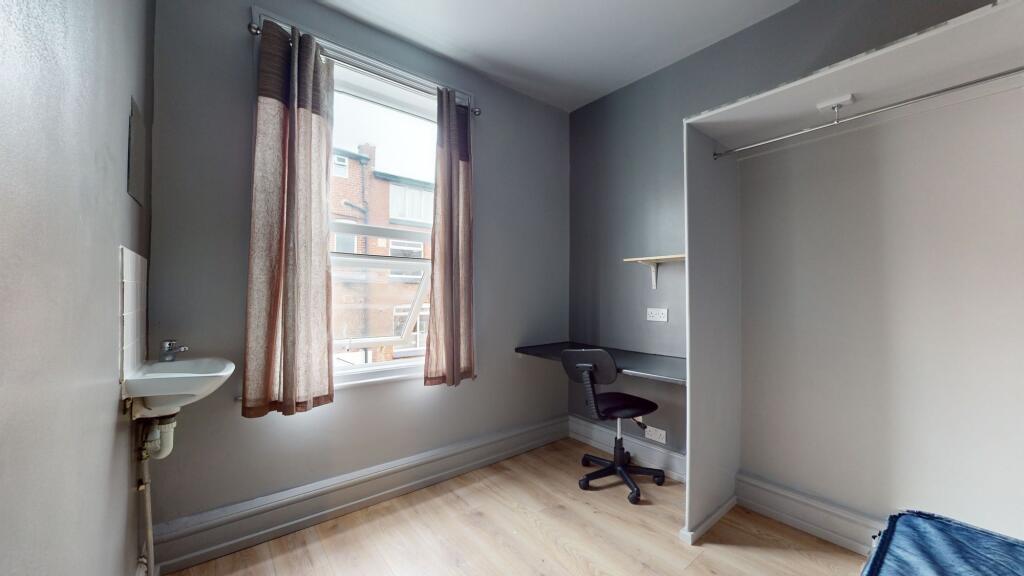 A simple, functional room featuring a large win...