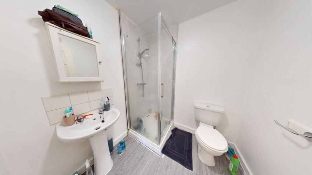 Bright and modern bathroom featuring a glass-en...