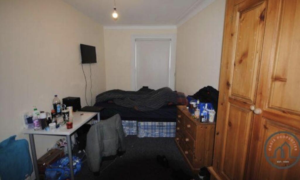 A cozy double bedroom featuring a large bed wit...