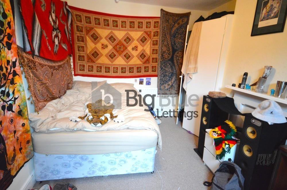 A cozy single bedroom featuring vibrant decorat...