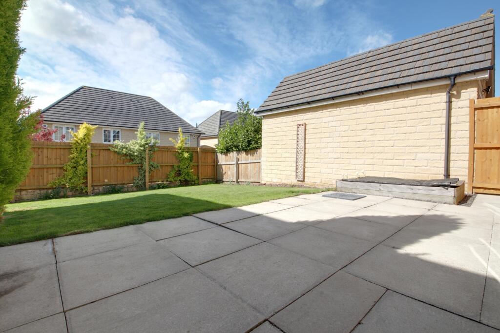 The back garden showing the patio and lawn