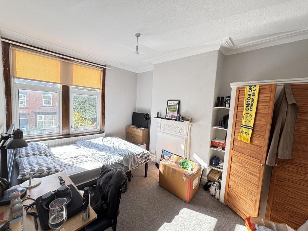 A cozy bedroom featuring a bed, a large window ...