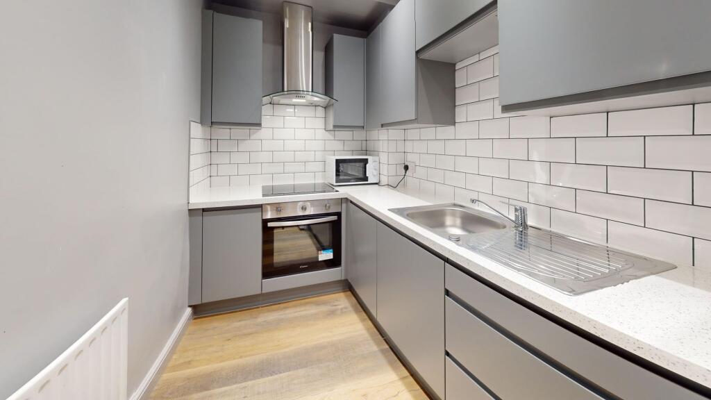 A modern, clean kitchen with sleek gray cabinet...