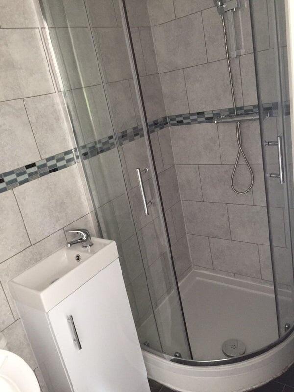 Modern bathroom featuring a curved glass shower...