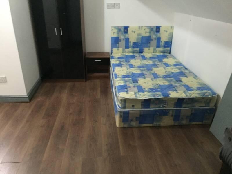 Neat furnished bedroom with a double bed, woode...