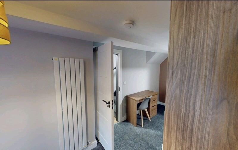 Bright, neatly furnished bedroom with neutral d...