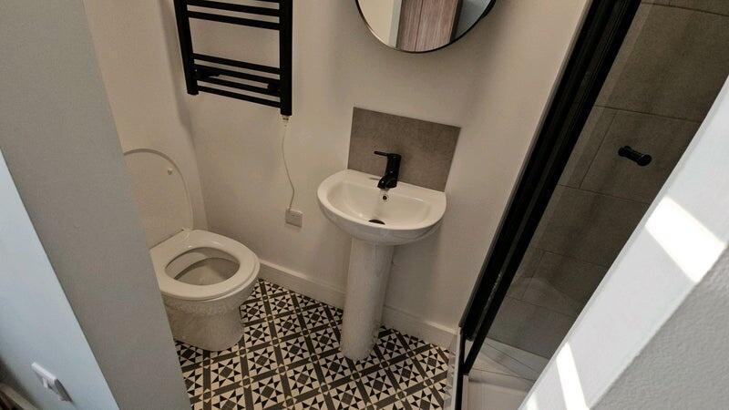 Compact modern bathroom with patterned tile flo...