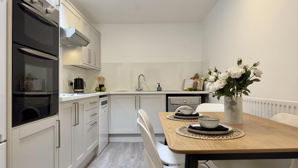 A bright and modern kitchenette with clean fini...