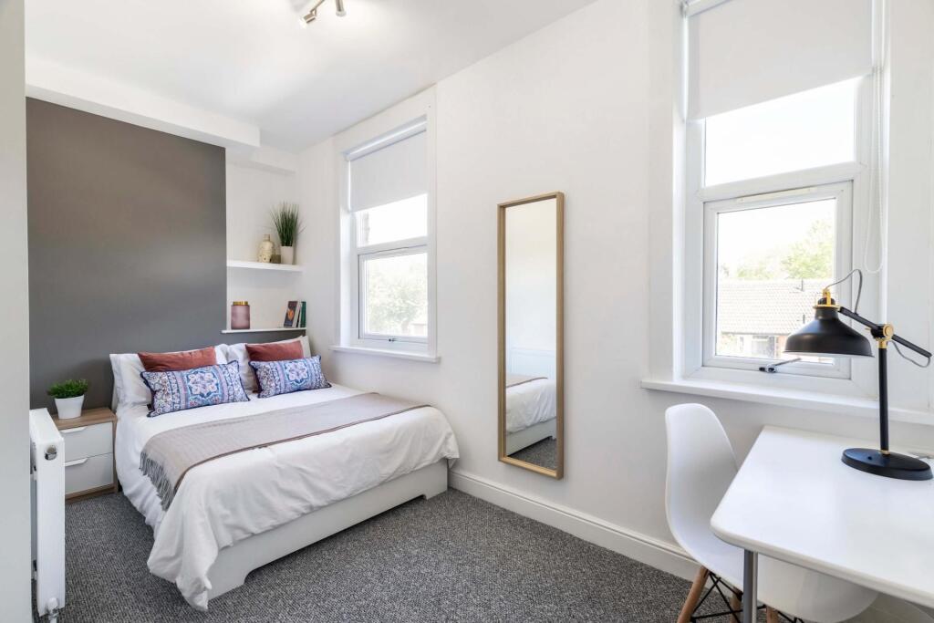 Bright and spacious master bedroom with large w...