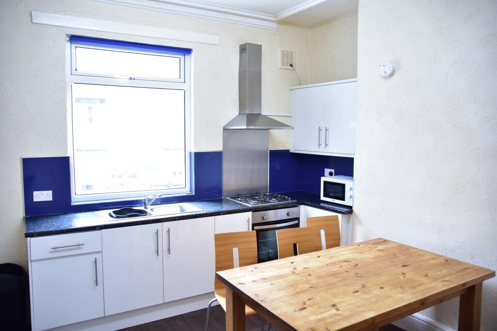 Bright and tidy kitchen featuring a large windo...