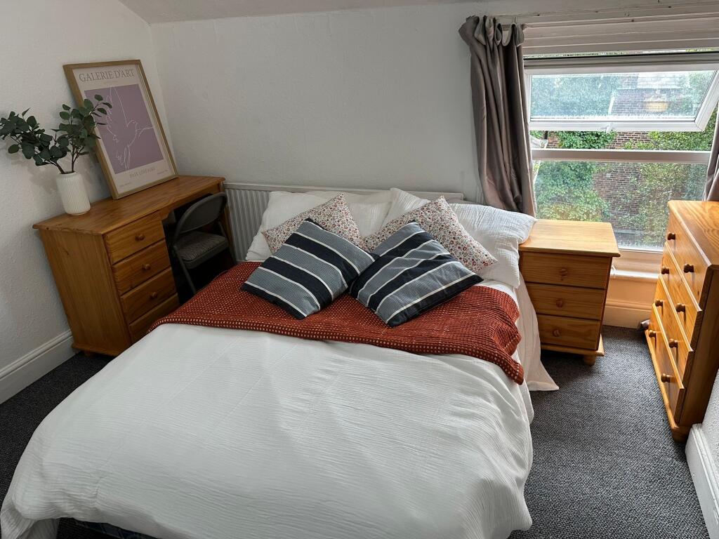 Spacious and welcoming bedroom featuring a comf...