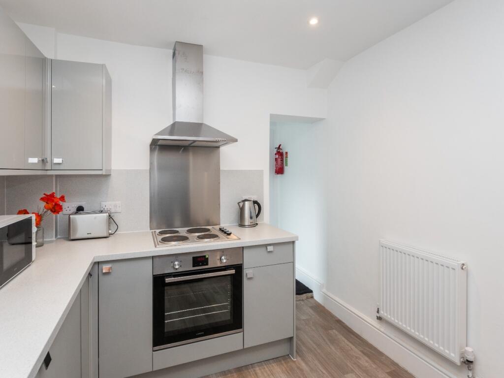 A modern, clean kitchen featuring sleek grey ca...