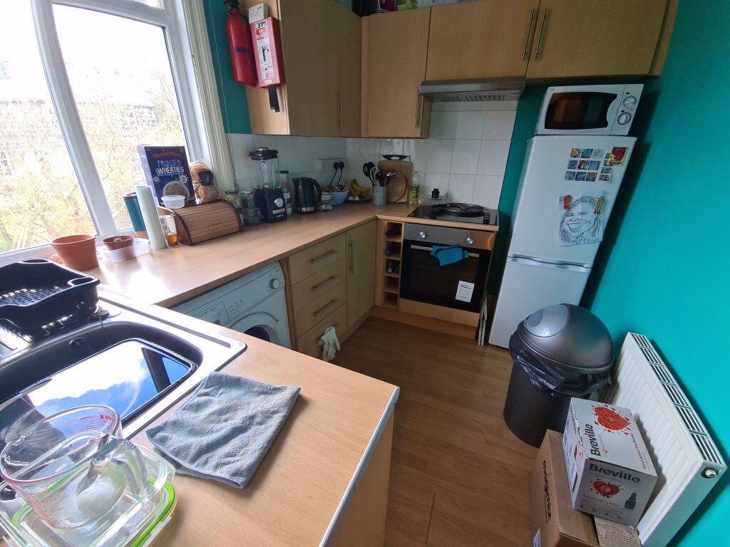 Bright, modern kitchen with integrated oven, mi...