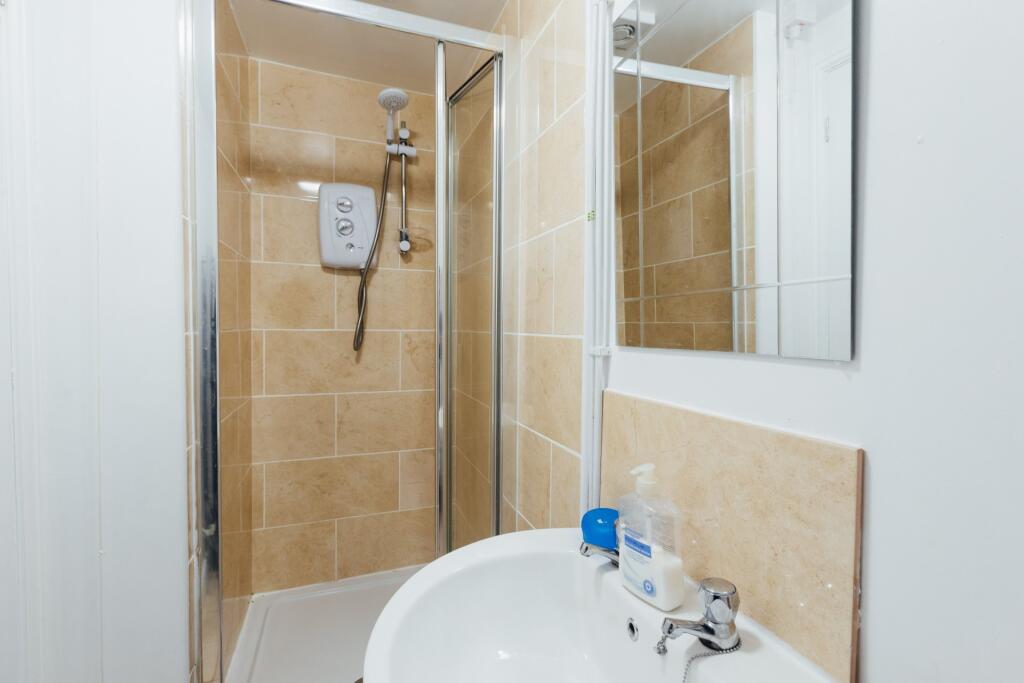 A clean and functional bathroom featuring a sho...