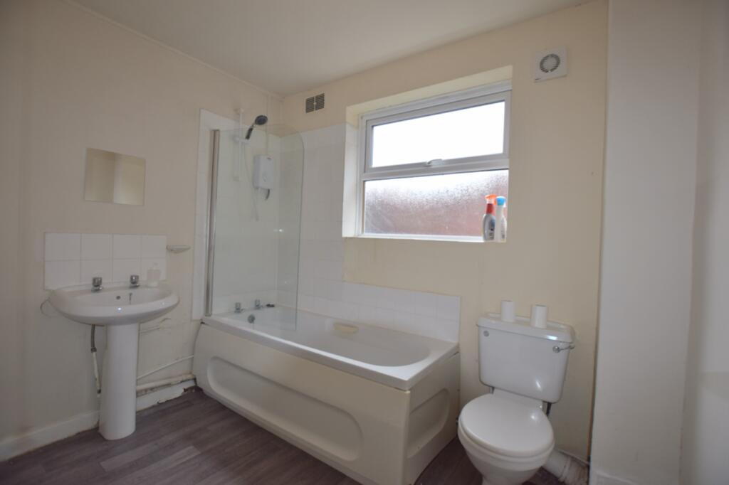 A modern and tidy bathroom featuring a bath and...