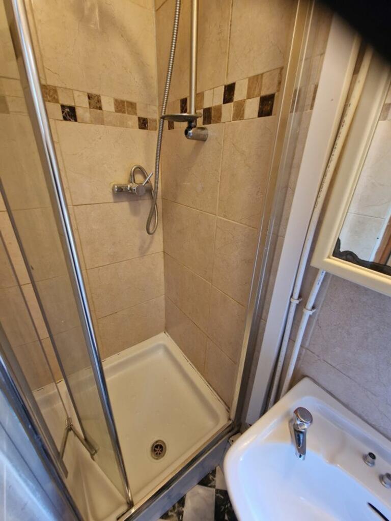 A tidy bathroom featuring a modern shower, perf...