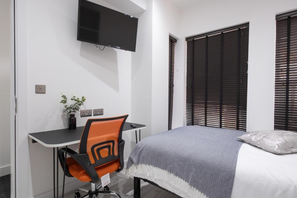 This inviting double bedroom features a comfort...