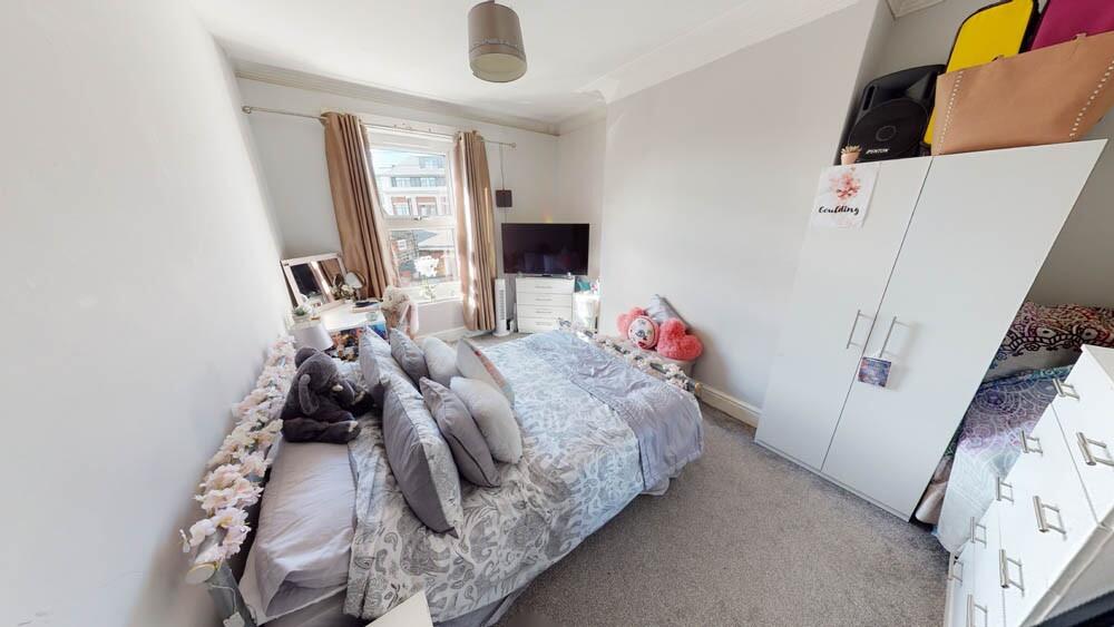 A cozy single bedroom featuring a comfortable b...