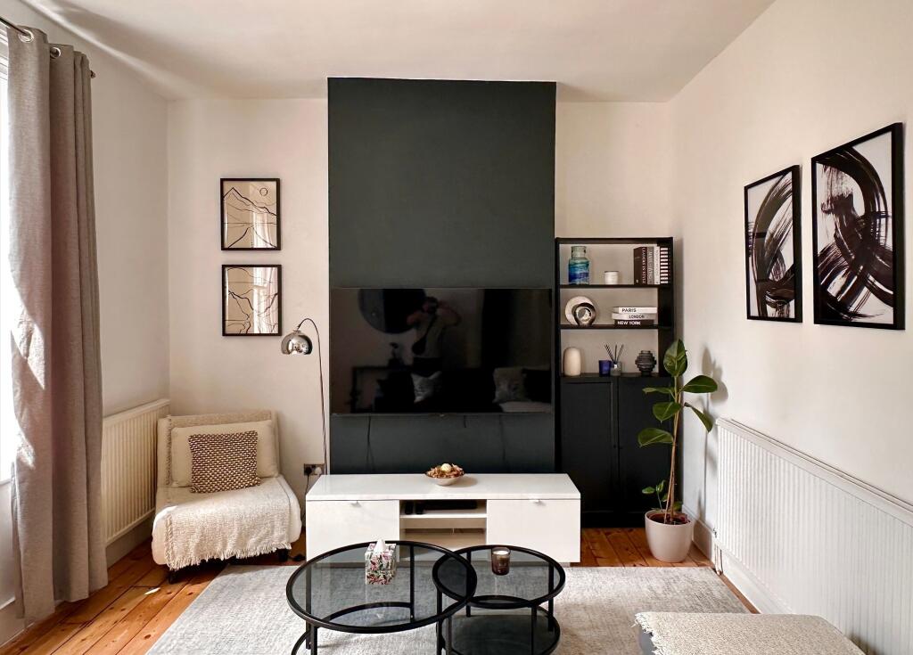 A stylish and contemporary living room featurin...