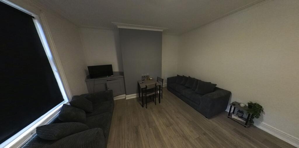 A spacious and well-lit living room featuring m...