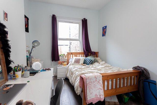 Cozy single bedroom featuring a comfortable woo...