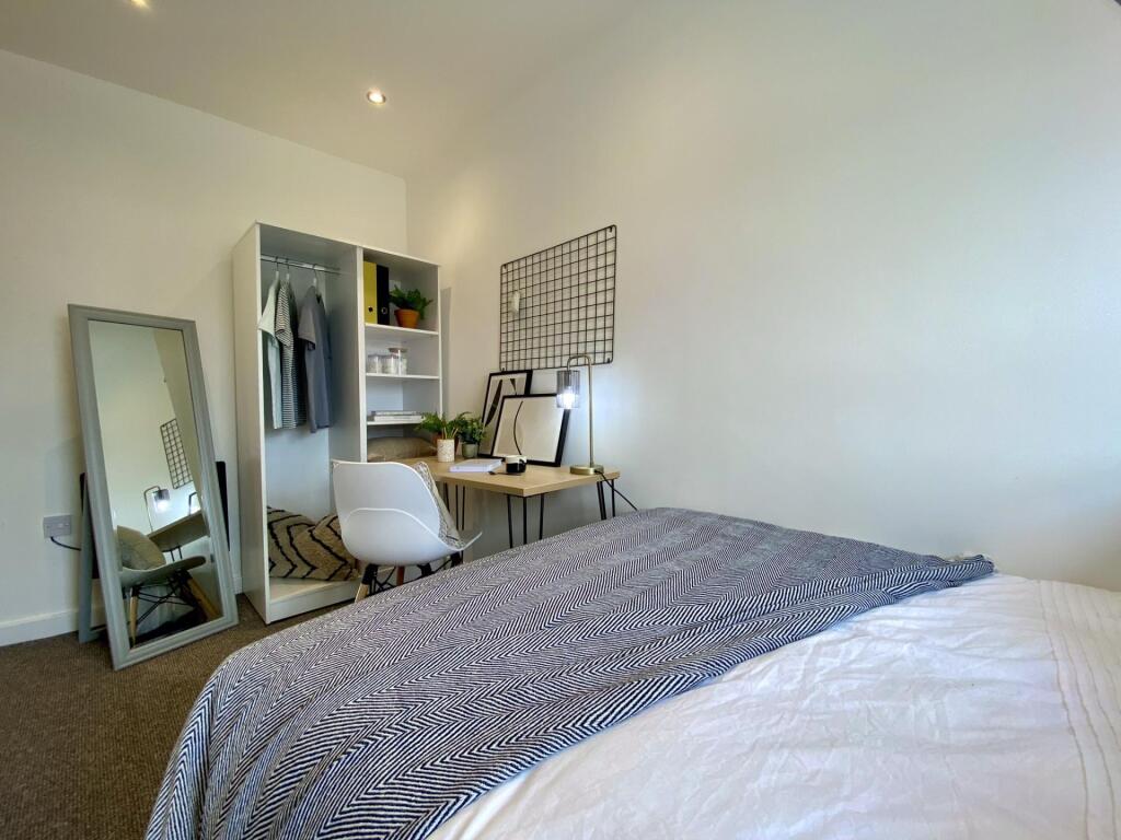 A bright and comfortable single bedroom featuri...