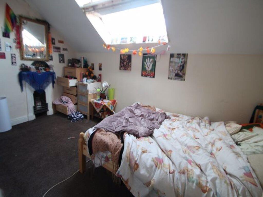 A cozy double bedroom with sloped ceilings and ...