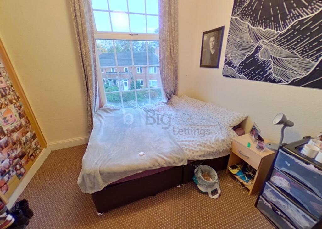 A cozy single bedroom featuring a comfortable b...