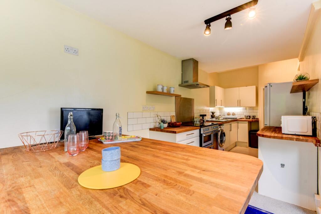 A modern, well-lit kitchen with wooden countert...