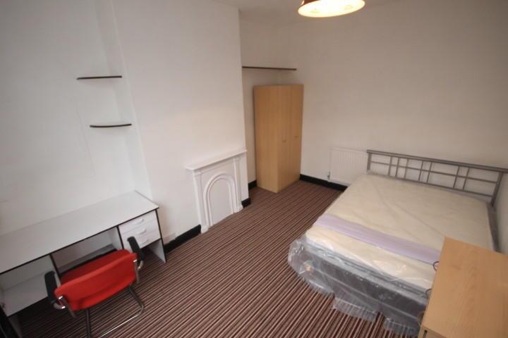 A simple, tidy single bedroom featuring a metal...