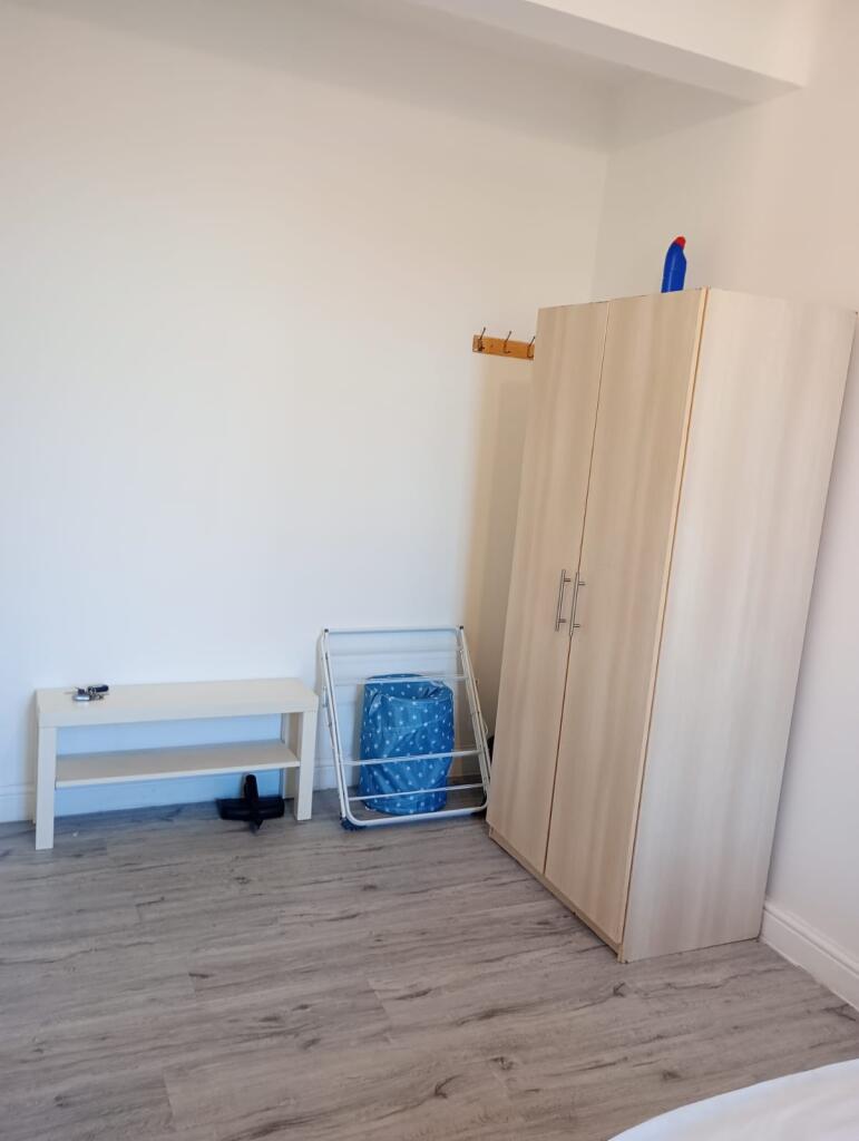 A clean and bright bedroom featuring a wardrobe...
