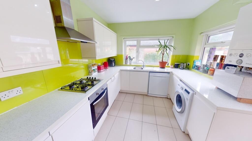Bright and modern kitchen featuring fresh green...