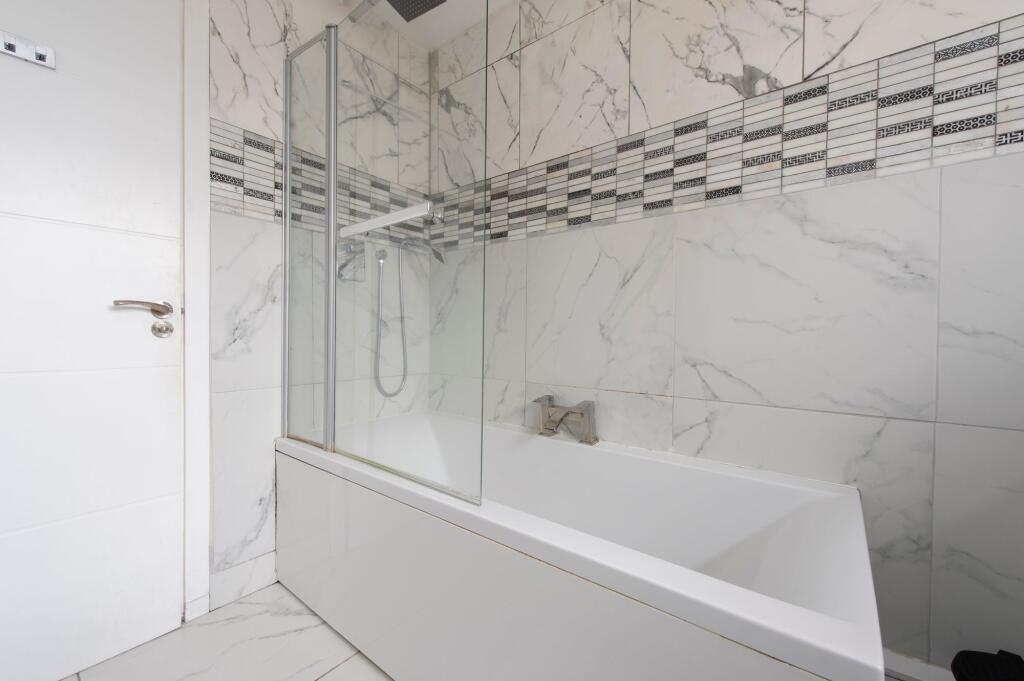 A modern bathroom featuring a sleek white batht...