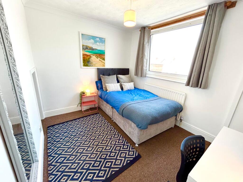 A bright and inviting double bedroom featuring ...