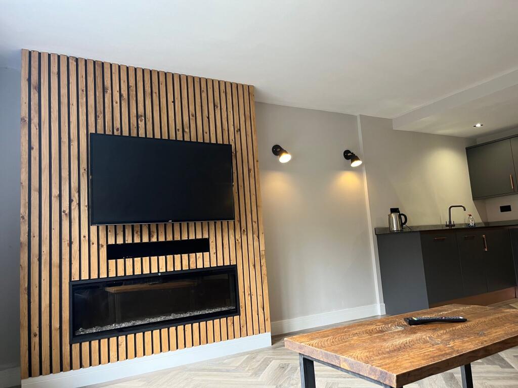 A modern living room featuring a stylish wooden...