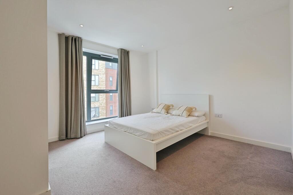 Bright and minimalistic bedroom featuring a lar...