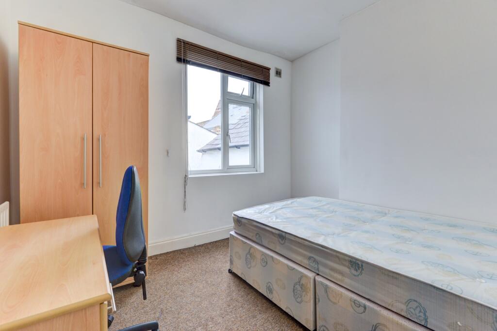 A bright and neat bedroom featuring a large win...