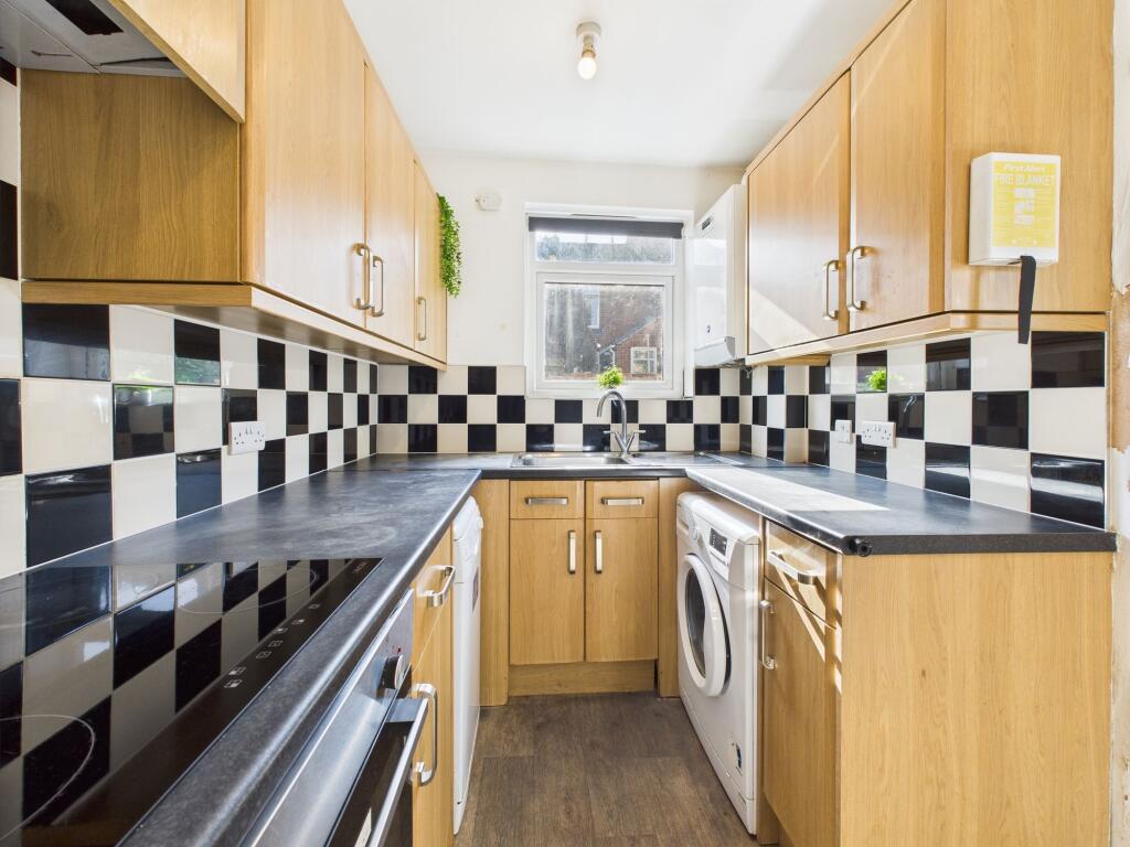 Bright and modern kitchen with wooden cabinets,...
