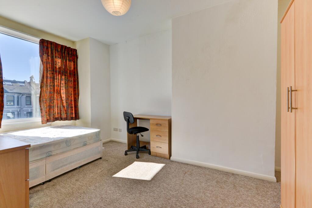 A bright and tidy single bedroom featuring a la...