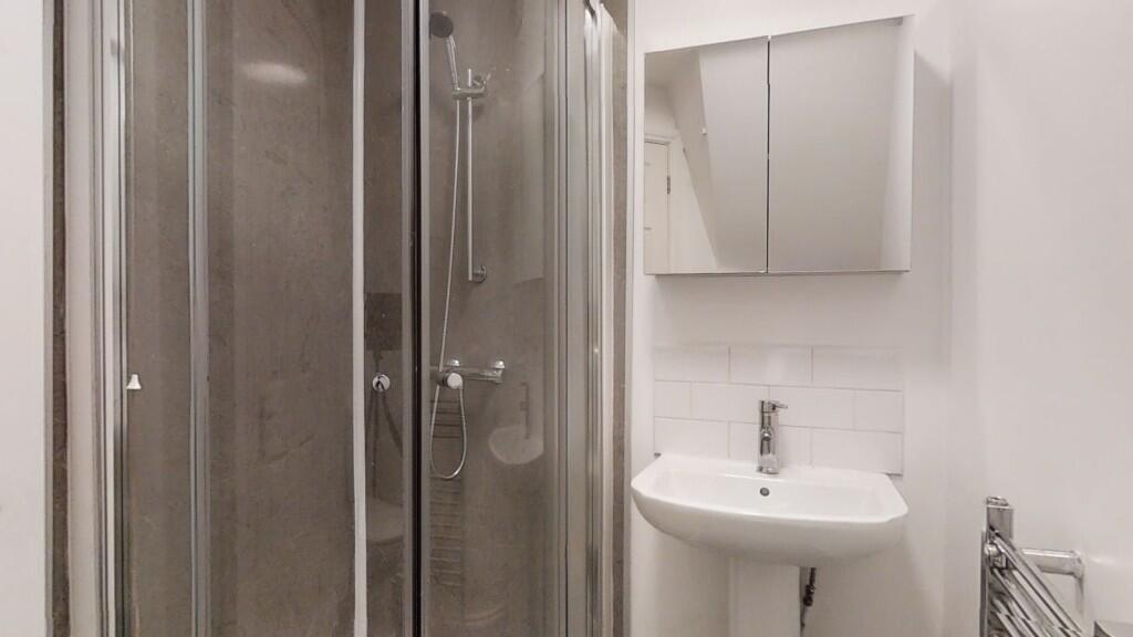 Bright and clean bathroom featuring a modern sh...