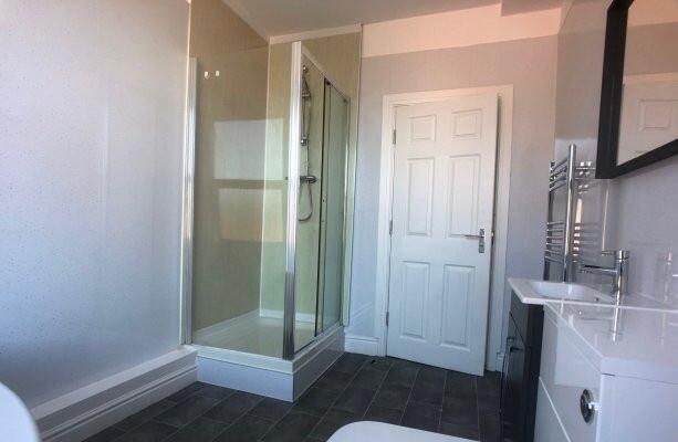 Modern bathroom suite featuring a shower enclos...