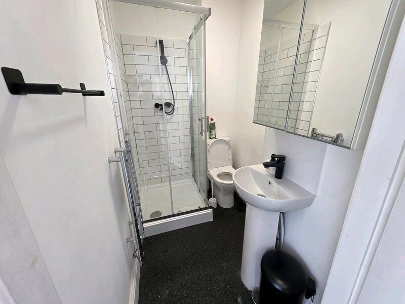 A clean and modern bathroom featuring a glass-e...