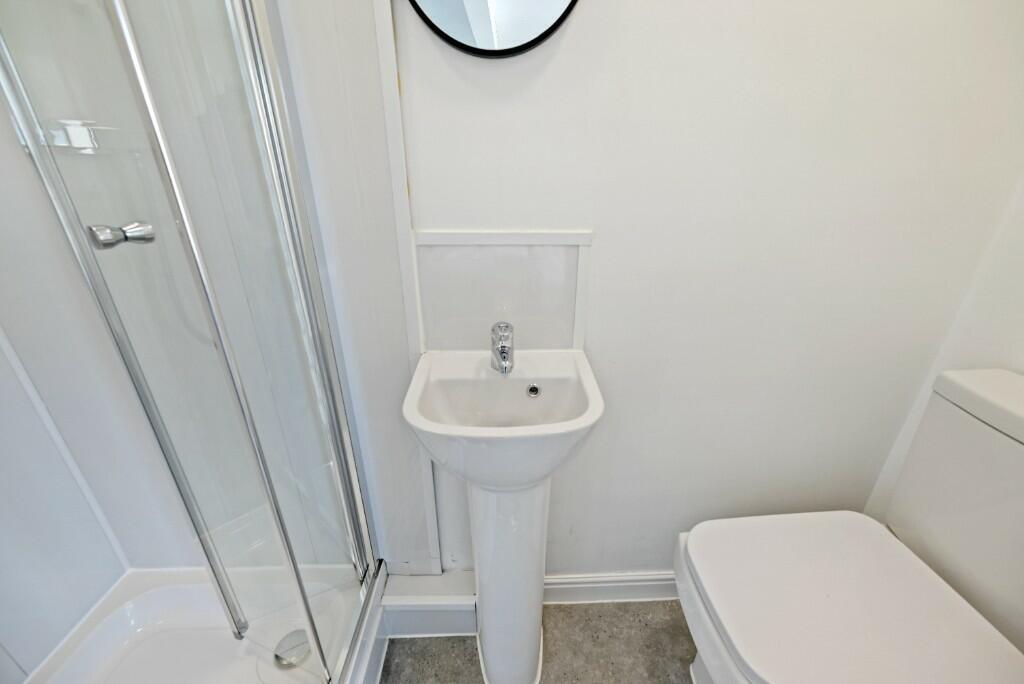 A neat and modern bathroom featuring a glass-en...
