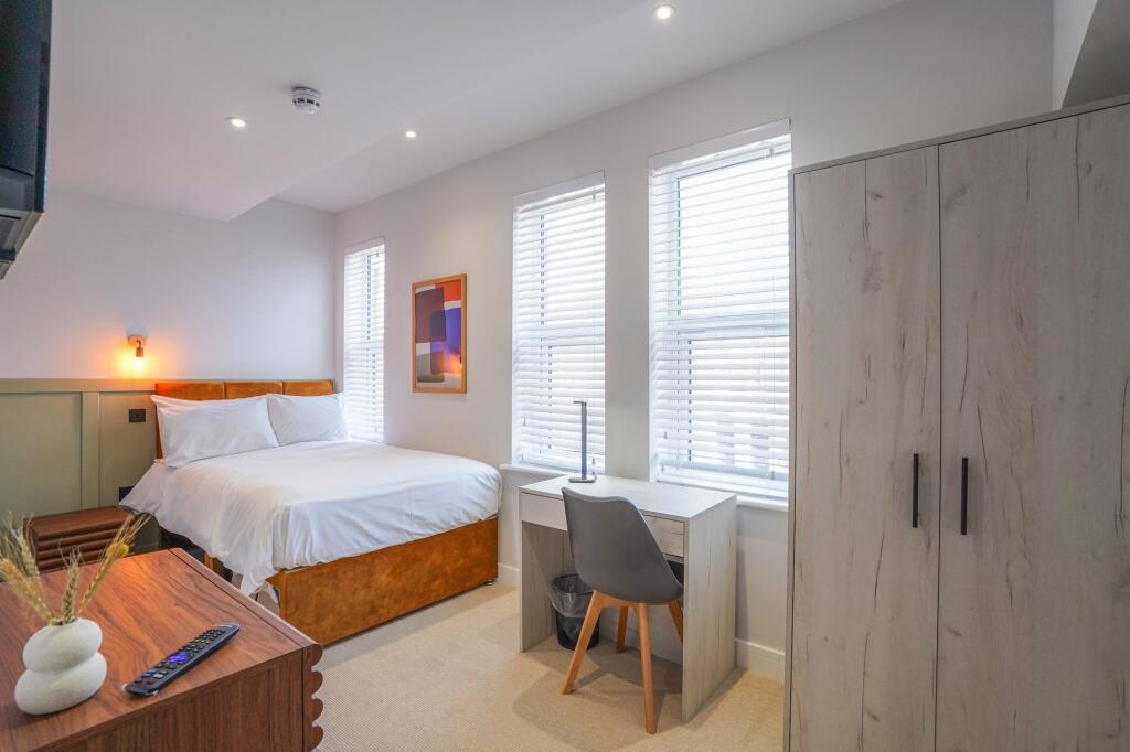 Bright and modern master bedroom featuring a la...