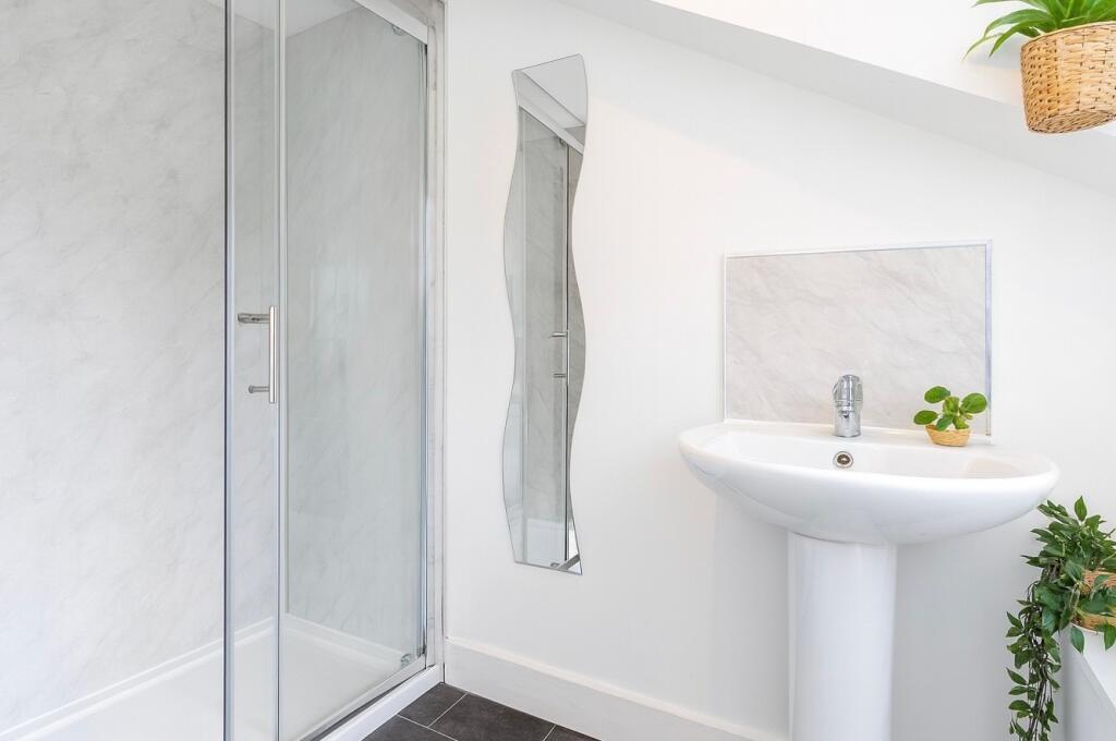 A pristine and modern bathroom featuring a glas...