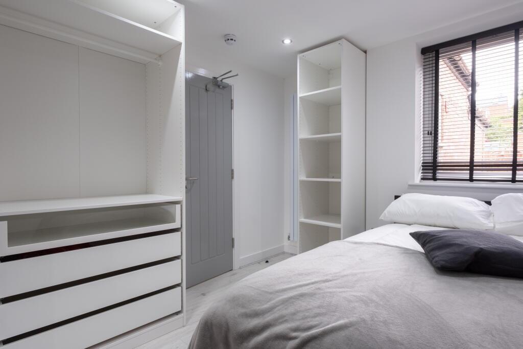 This bright and modern double bedroom features ...